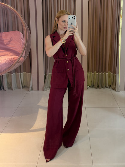Modelo vestindo conjunto feminino Marrant com colete alongado sem mangas, faixa para amarração na cintura e calça pantalona de alfaiataria.
